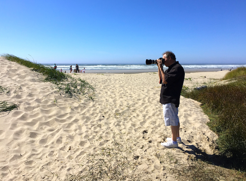 photographer with camera on beach