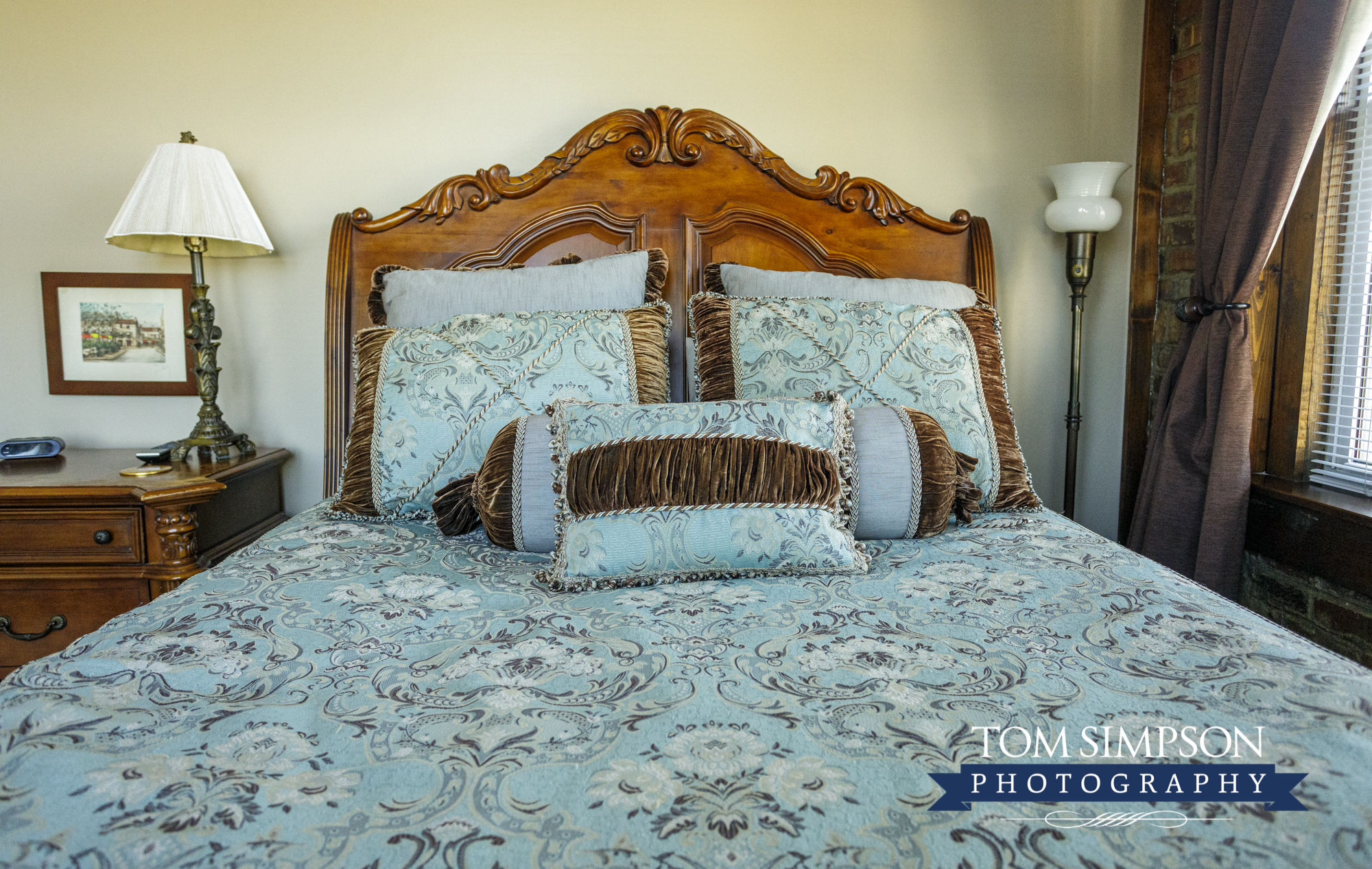 light teal floral bedding with brown velvet on antique bed