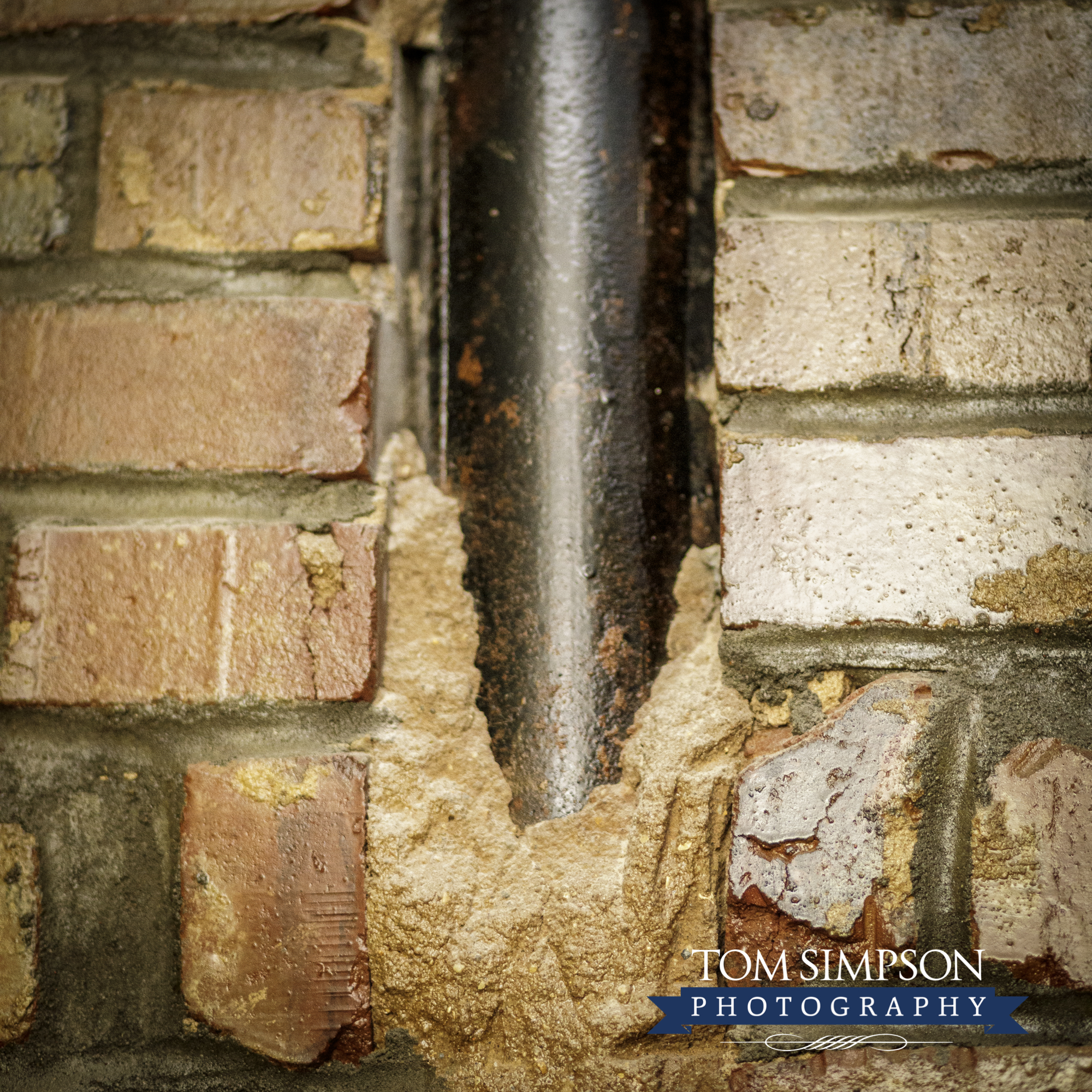 exposed pipe between bricks
