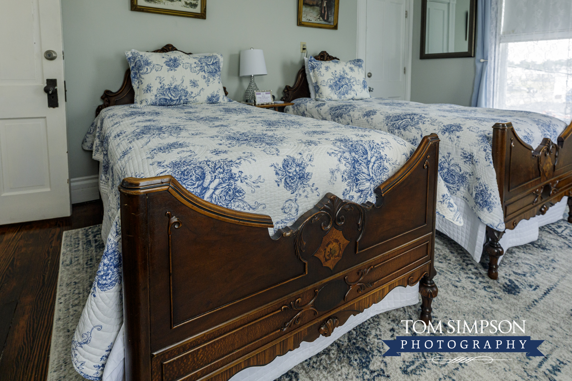 antique bed with blue white bedspreads