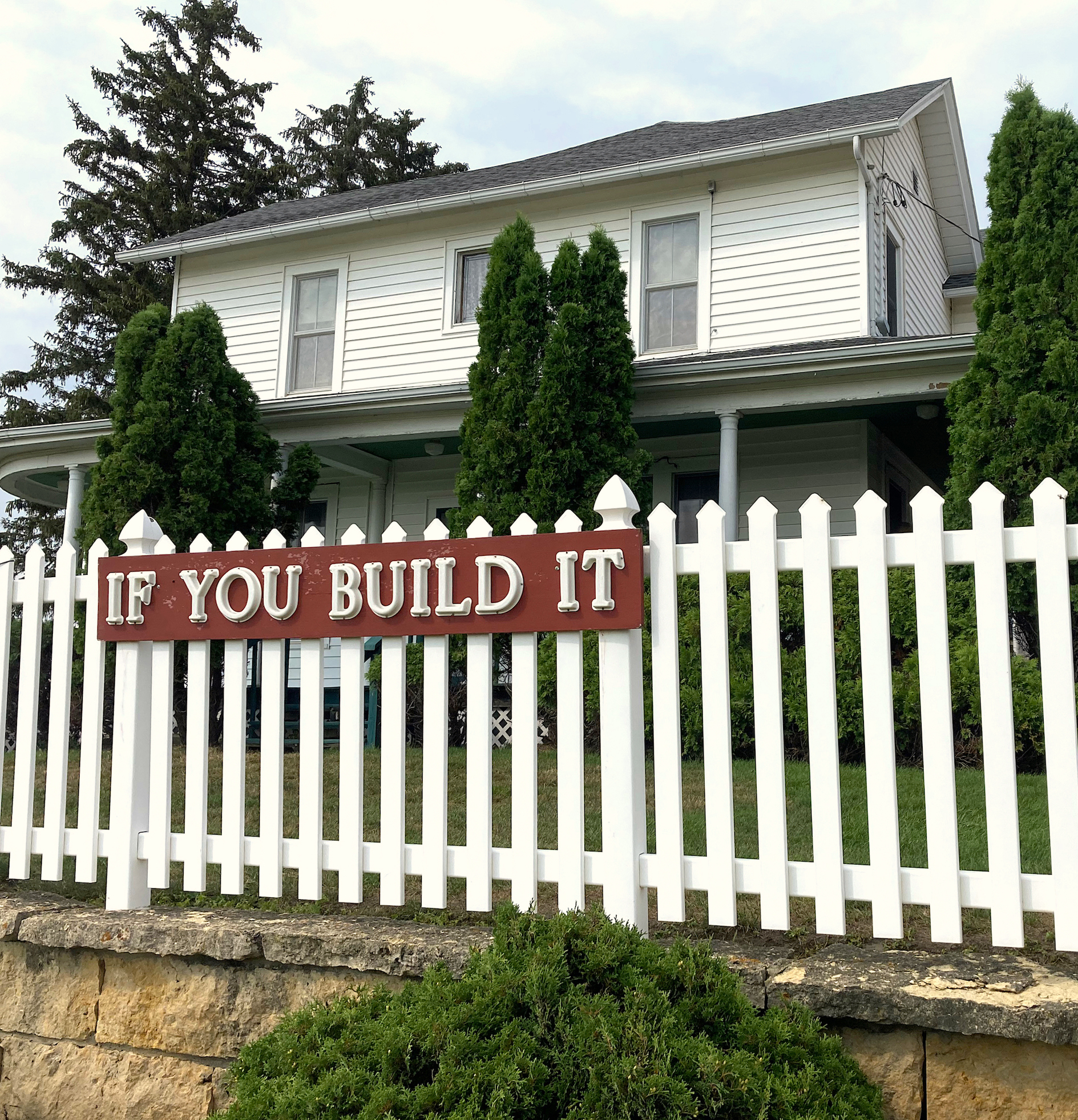white picket fence with if you build it sign in red